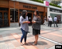 Richa Sharma (left) and Khushboo Gutt (right) enjoy the different experience offered by modern Indian food in restaurants like Farzi cafe. (A. Pasricha/VOA)