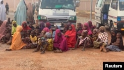 Women and children who were kidnapped in the northwestern state of Zamfara sit after being rescued by the Nigerian security agents in Zamfara, Nigeria, October 7, 2021.
