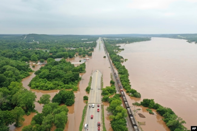 The Arkansas River spills over, flooding a highway in Sand Spring, Okla., May 28, 2019.