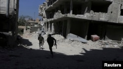 FILE - Fighters from the Free Syrian Army's Al Rahman legion run to avoid snipers on the frontline against the forces of Syria's President Bashar al-Assad in Jobar, a suburb of Damascus, Syria July 27, 2015. (REUTERS/Bassam Khabieh)