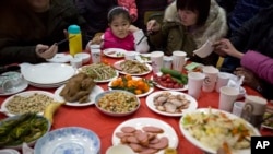 中国一名女孩看着桌上满满的食物