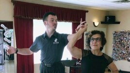In this October 7, 2019, photo, dance instructor Ned Pavlovic, a native of Serbia, teaches his student Rouhy Yazdani, a native of Iran who now lives in Milford, Connecticut, some ballroom dance moves at the Fred Astaire Dance Studio in Orange, Connecticut