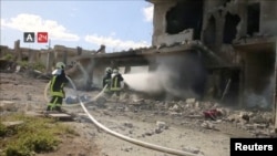 FILE - Firefighters respond at the destroyed building of Nabd Al-Hayat hospital that was hit by an airstrike in Hass, Idlib province, Syria, May 6, 2019, in this still image taken from a video on May 9, 2019. 