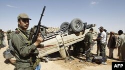 Туніський солдат стоїть біля знищеної машини лівійських військ