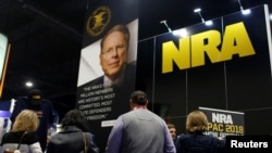 FILE - People sign up at the booth for the National Rifle Association at the Conservative Political Action Conference at National Harbor, Maryland, Feb. 23, 2018.
