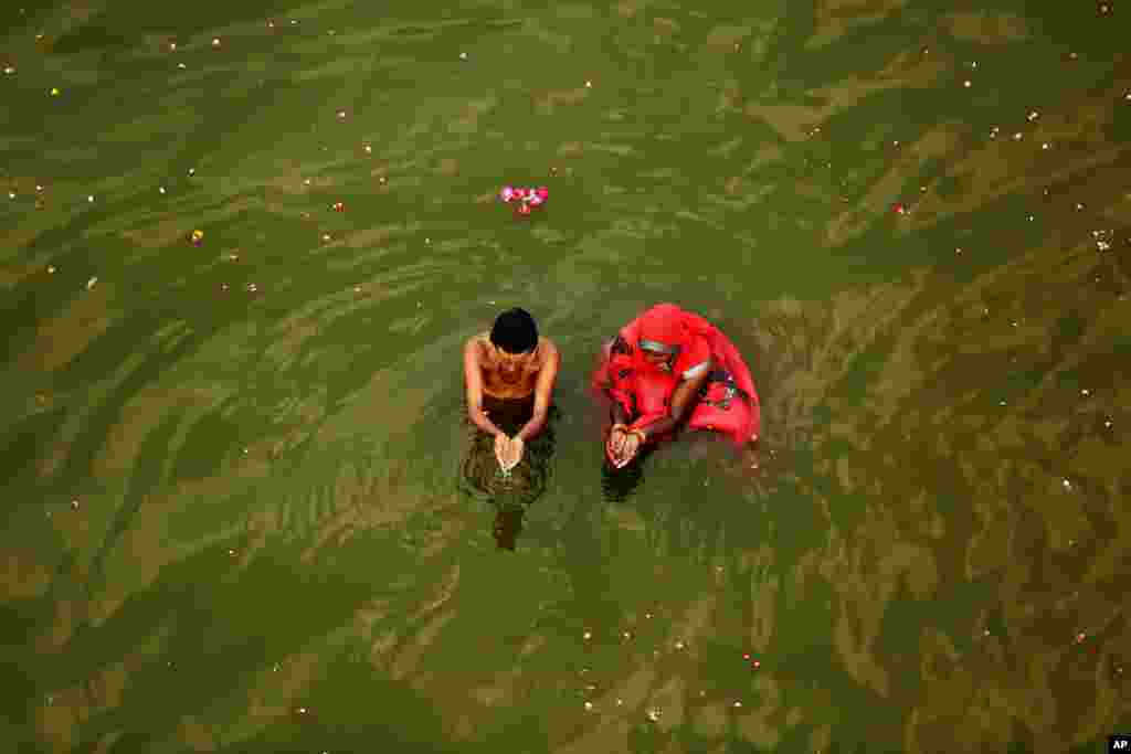 یک زوج هندی آیین مذهبی صبحگاهی هندو را در رودخانه گنگ برگزار می&zwnj;کنند.