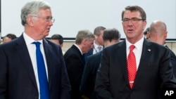 U.S. Secretary of Defense Ashton Carter, right, speaks with British Secretary of State for Defense Michael Fallon at the start of a meeting at EU headquarters in Brussels, June 24, 2015.