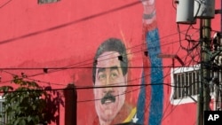 FILE - A mural of Venezuela's President Nicolas Maduro can be seen on the wall of a house in the popular neighborhood of Petare in Caracas, Venezuela.