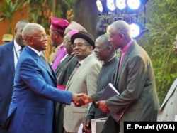 Presidential aspirant and former Prime Minister Amama Mbabazi arrives at the debate in Kampala, Feb. 13, 2016, greeted by the Inter-Religious Council of Uganda.