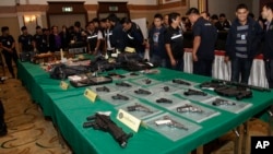 FILE - Thai police officials display seized guns before a press conference in Bangkok, Thailand, Oct. 28, 2015.