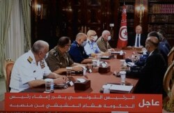 Le président tunisien Kais Saied annonce la dissolution du parlement et du gouvernement du Premier ministre Mechichi alors qu'il est assis avec son état-major militaire le 25 juillet 2021 au Palais de Carthage. (Capture d'écran de la télévision)