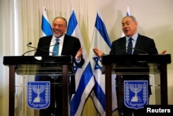 Avigdor Lieberman, head of far-right Yisrael Beitenu party, (L) and Israeli Prime Minister Benjamin Netanyahu deliver statements to the media after signing a coalition deal to broaden the government's parliamentary majority, at the Knesset.