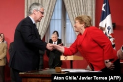 Chile's new finance minister, Nicolas Eyzaguirre (L), shakes hands with President Michelle Bachelet at La Moneda Presidential Palace in Santiago, Aug. 31, 2017.