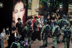 Polisi memeriksa para pejalan kaki di Causeway Bay, Hong Kong, pada Hari Nasional China, Kamis, 1 Oktober 2020. (Foto AP / Kin Cheung)