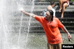 A man enjoys a cooling spray from a fountain during a heat wave in Manhattan, New York, July 23, 2016.