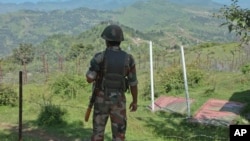 FILE- Indian army soldier guards near fence on the line of control near Balakot sector in Poonch, Jammu and Kashmir, India, Aug.17, 2015. 