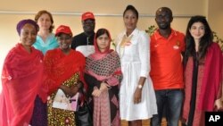 Pakistani activist Malala Yousafzai, who survived being shot by the Taliban because she advocated education for girls, poses for a photograph with the organizers of Bring Back Our Girls campaign, in Abuja, Nigeria, July 13, 2014. 