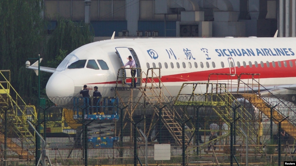 Para pekerja memeriksa pesawat terbang milik Sichuan Airlines yang melakukan pendaratan darurat setelah kaca jendela depan di kokpit pecah, di sebuah bandara di Chengdu, Provinsi Sichuan, 14 Mei 2018.