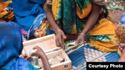 FILE - Women participate in a CARE Village Savings and Loan Association program in East Hararghe, Ethiopia. With a lockbox and some basic training, women can start small businesses and build financial independence. (Michael Tsegaye/CARE)