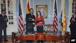 Bolivia's Deputy Foreign Minister Juan Carlos Alurralde [2nd L] and U.S. State Department senior official Maria Otero pose after signing an agreement in La Paz, Bolivia, November 7, 2011.