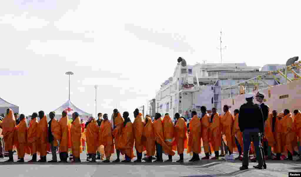 Migrants stand in line after disembarking from the Norwegian vessel Siem Pilot at Pozzallo&#39;s harbor, Italy.