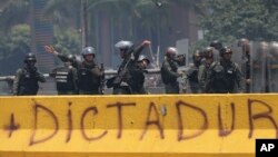 Un oficial de la Guardia Nacional Bolivariana de Venezuela lanza una granada de gas lacrimógeno contra los manifestantes durante una protesta en Caracas, Venezuela. Foto de archivo.