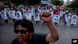 Relatives of the 43 missing students from the Isidro Burgos rural teachers college march holding pictures of their missing loved ones during a protest in Mexico City, July 26, 2015.