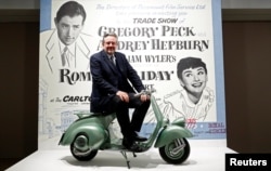 Audrey Hepburn's son, Sean Hepburn Ferrer, poses on the Vespa scooter his mother rode on in the 1953 movie "Roman Holiday" at the exhibition "Intimate Audrey" in Brussels, Belgium, May 2, 2019. (REUTERS/Francois Lenoir)