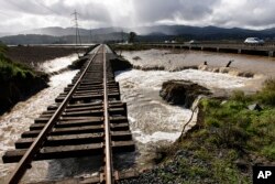 Water from recent heavy rain storms breeched a levee and flows under railroad tracks in Novato, Calif., Feb. 14, 2019.
