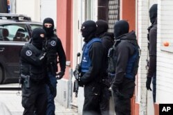 Armed police guard a street in Brussels on Nov. 16, 2015. A major action with heavily armed police is underway in the Brussels neighborhood of Molenbeek amid a manhunt for a suspect of the Paris attacks.