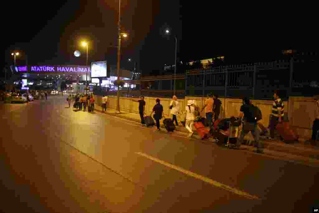 Menyusul evakuasi setelah ledakan bom, para penumpang berjalan keluar dari bandar udara Ataturk, Istanbul (28/6). (AP/Emrah Gurel)