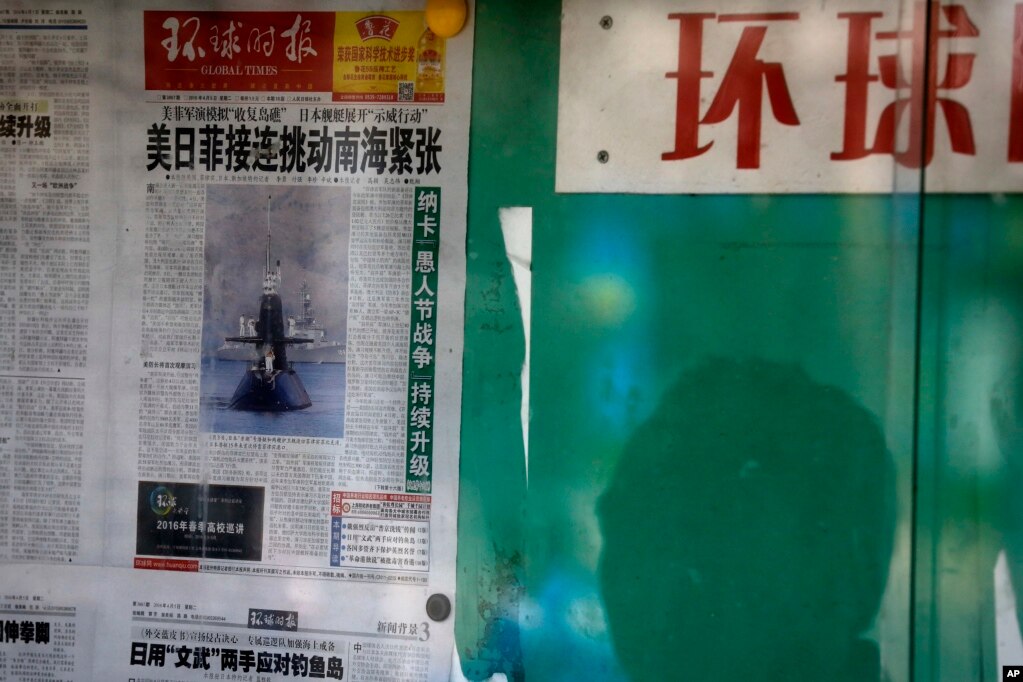 资料照：北京街头一名男子在读一处报栏里张贴的环球时报。 （2016年4月5日）(photo:VOA)