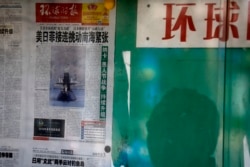 资料照：北京街头一名男子在读一处报栏里张贴的环球时报。 （2016年4月5日）