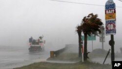 Un camión de trabajo avanza por la Autopista 24 (Hwy 24) mientras el viento del huracán Florence dobla las palmas en Swansboro, Carolina del Norte, el jueves 13 de septiembre de 2018. (AP/Tom Copeland).