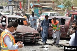 Members of the bomb disposal unit survey the site after a suicide blast, in Quetta, Pakistan July 25, 2018. REUTERS/Naseer Ahmed