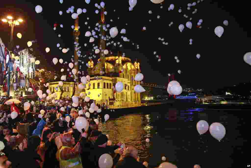 La gente libera globos y linternas en el aire en el distrito de Estambul Ortakoy por el Bósforo, durante las celebraciones de Año Nuevo. (Foto AP)