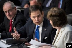 FILE - Senate Intelligence Committee members Marco Rubio, R-Fla., center, and Susan Collins, R-Maine, confer on Capitol Hill in Washington, June 28, 2017, as the committee conducts a hearing on Russian intervention in European elections in light of revelations by American intelligence agencies that blame Russia for meddling in the 2016 U.S. election. Sen. Jim Risch, R-Idaho, is at left.