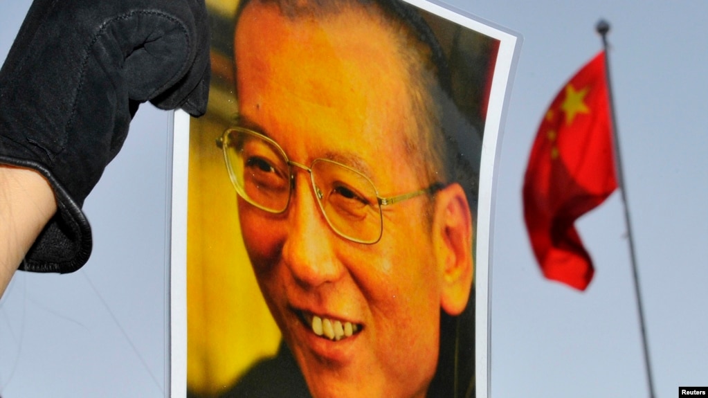 一位抗议者在中国驻奥斯陆大使馆门外举着刘晓波的照片。(资料照)