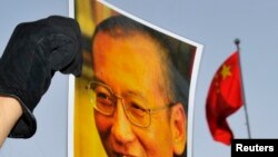 一位抗议者在中国驻奥斯陆大使馆门外举着刘晓波的照片。（资料照）