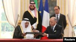 هاشم بن عبدالله یمانی رئیس شهرک اتمی ملک عبدالله در حال امضای قرارداد با وزیر خارجه وقت فرانسه - پاریس، ۲۴ ژوئن ۲۰۱۵ 