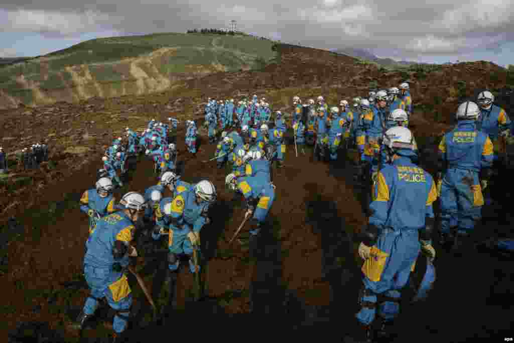 Rescue workers search for missing people at a massive landslide caused by a magnitude 7.3 strong earthquake in Minamiaso, Kumamoto Prefecture, southwestern Japan.