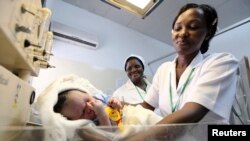 FILE - A nurse weighs a baby at the Maitama district hospital in Nigeria's capital of Abuja, May 22, 2011. 