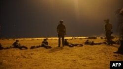 In this photo released by the U.S. Army on March 9, 2017, U.S. Army Special Forces soldiers observe as Nigerien armed forces service members fire their weapons with the assistance of illumination rounds during an exercise in Diffa, Niger. Four U.S. servicemen were killed in the country during an ambush by militants last month.