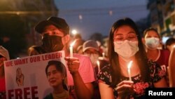 FILE - People hold candles as they take part in an anti-coup night protest at Hledan junction in Yangon, Myanmar, March 14, 2021.