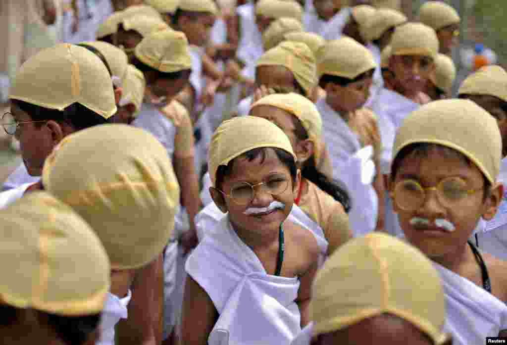 Schoolchildren dressed as Mahatma Gandhi take part in an attempt to set a new Guiness World Record, for the largest gathering of people dressed as Gandhi, during celebrations to mark his 146th birth anniversary, in Bengaluru, India.