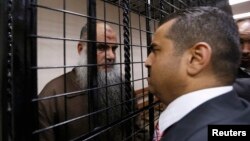 Radical Muslim cleric Abu Qatada, left, speaks with his lawyer Hussein Mubadeen after his trial at the State Security Court in Amman, Jordan, June 26, 2014. 