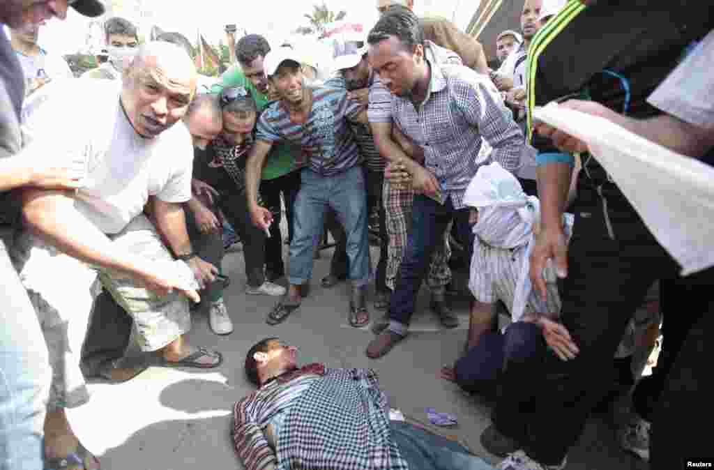 Protesters who support former Egyptian President Mohamed Morsi gather around the body of a man during clashes outside the Republican Guard building in Cairo, July 5, 2013.