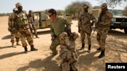 FILE - A U.S. special forces soldier demonstrates how to detain a suspect during Flintlock 2014, a U.S.-led international training mission for African militaries, in Diffa, March 4, 2014.