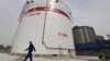 FILE - An employee walks past oil tanks at a Sinopec refinery in Wuhan, Hubei province April 25, 2012. China’s top state-owned refiners have decided not to order any oil for loading at Iranian ports this month, according to Reuters.