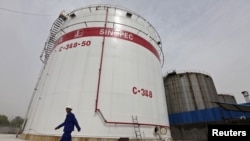 ไฟล์ - พนักงานเดินผ่านถังน้ำมันที่โรงกลั่นน้ำมัน Sinopec ในเมืองอู่ฮั่น มณฑลหูเป่ย์ เมื่อวันที่ 25 เมษายน 2012
ພະນັກງານຍ່າງຜ່ານຖັງນໍ້າມັນທີ່ໂຮງກັ່ນນໍ້າມັນ ຊິໂນເປັກ ໃນເມືອງ ອູ່ຮັ້ນ ມົນທົນຫູເປ ເມື່ອວັນທີ 25 ເມສາ 20ຢຟ